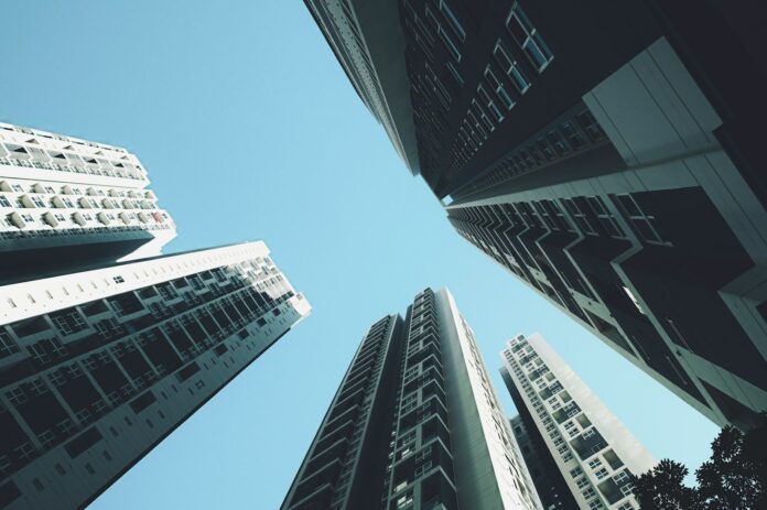 Photo by Clark Gu looking up at tall buildings in a city