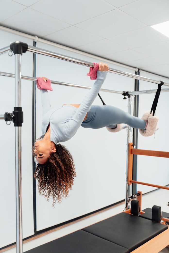a woman is doing a handstand on a parallel bar