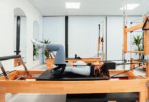 최근 30~40대가 관심가지는 필라테스로 건강관리 하는 법 a woman is doing a pivot on a pivot machine