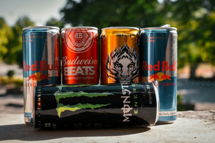 Photo by Garv Chaplot a group of four cans of soda sitting next to each other