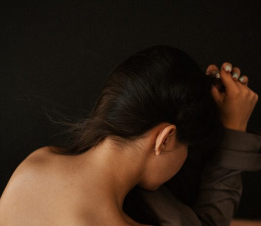 “어깨가 항상 묵직해요”… 거북목에서 시작된 ‘신경통’ 신호일 수 있습니다 a woman in a brown dress holding her hair back