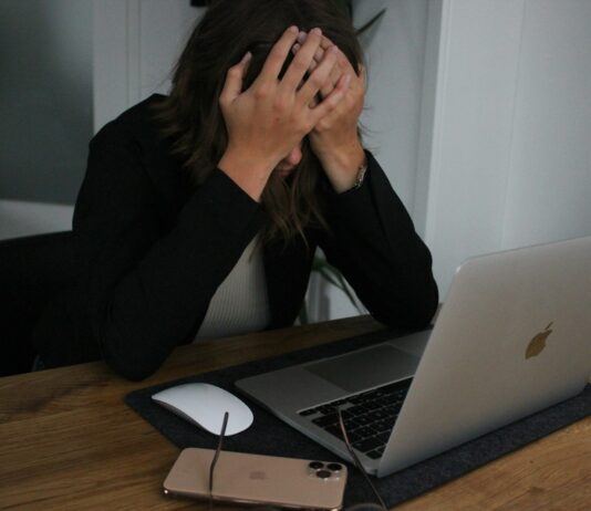 스트레스 관리, 건강한 삶을 위해 꼭 실천해야 할 습관 a woman covering her face while looking at a laptop