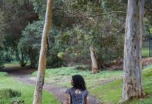 돌봄보다 ‘셀프케어’… 일상 속 건강 지키는 소소한 루틴 인기 a woman is walking down a path in the woods