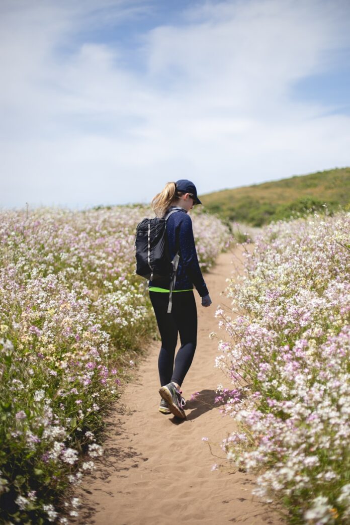 Photo by Matt Flores woman walking between flower fields