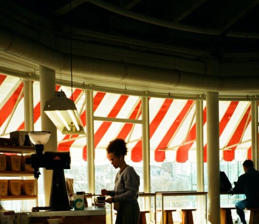 번아웃 예방하기: “의지력도 소모품이다,” 운동 권태기를 극복하는 멘탈 관리법 Barista working behind counter in sunlit cafe