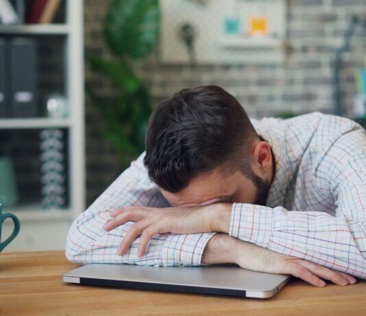 만성피로, 일상 속 작은 변화로 극복한다 a man sitting at a desk with his head in his hands