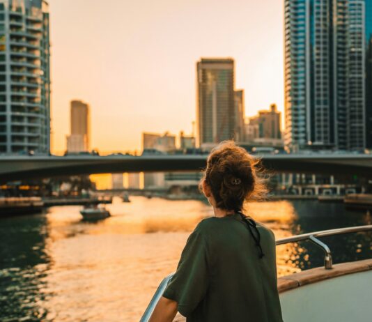 ‘마음챙김 걷기’, 일상 속 무거운 스트레스 걷어내는 새 건강 트렌드 Woman on boat overlooking city skyline at sunset